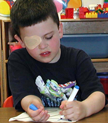 Child with patch to help correct lazy eye or amblyopia